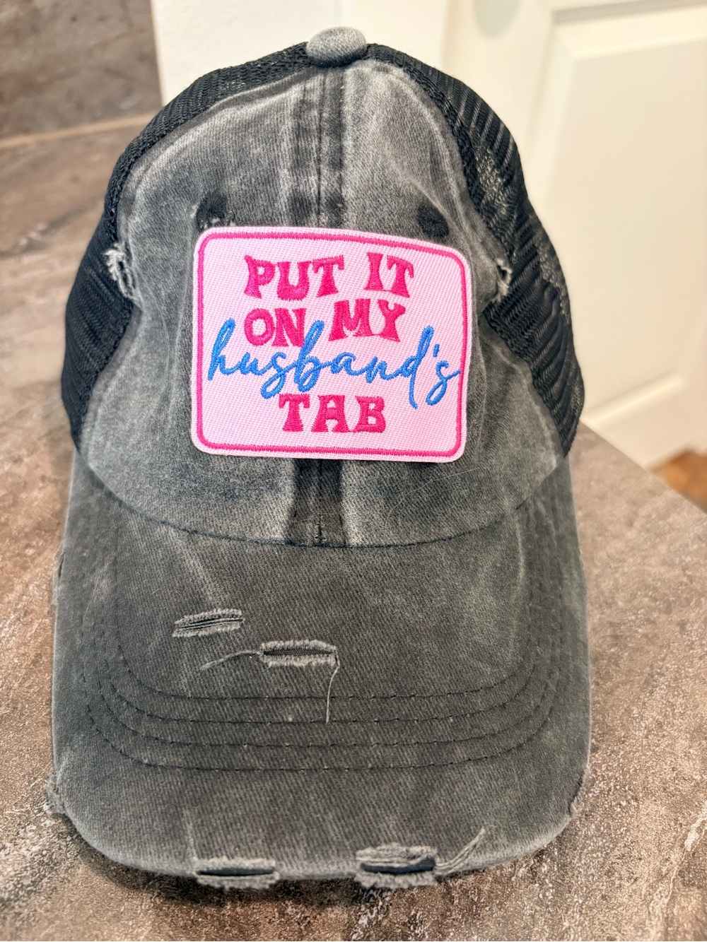 Grey Distressed Trucker Hat with Pink Patch - "Put It On My Husband's Tab"